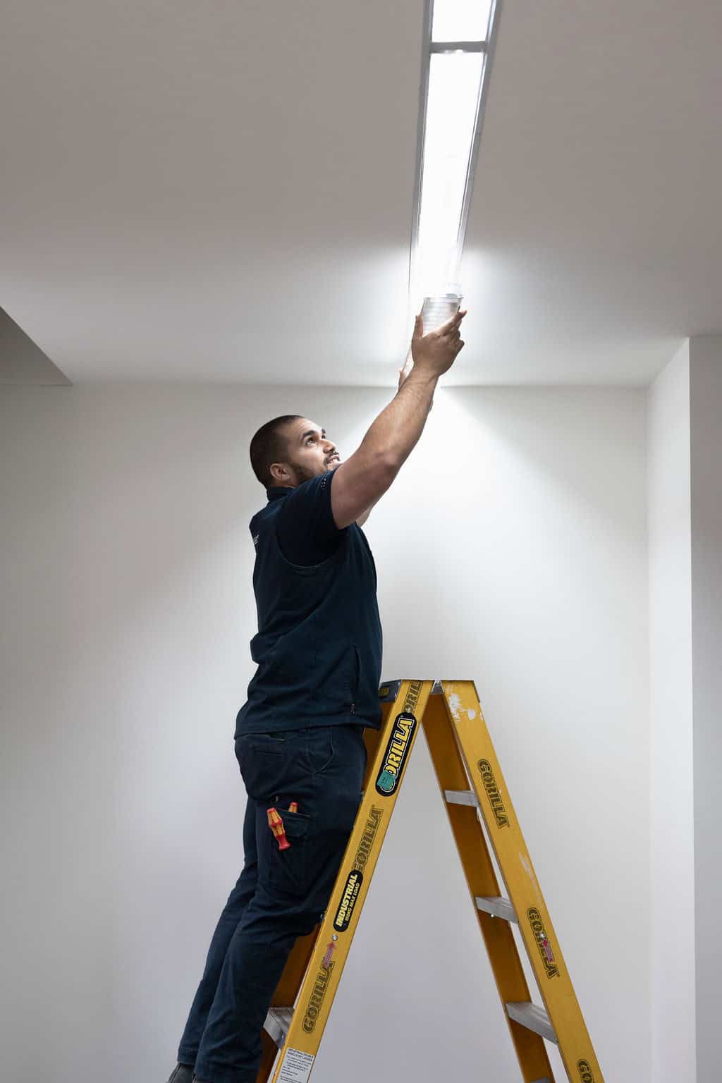 Professional electrician installing LED ceiling lights in Albert Park