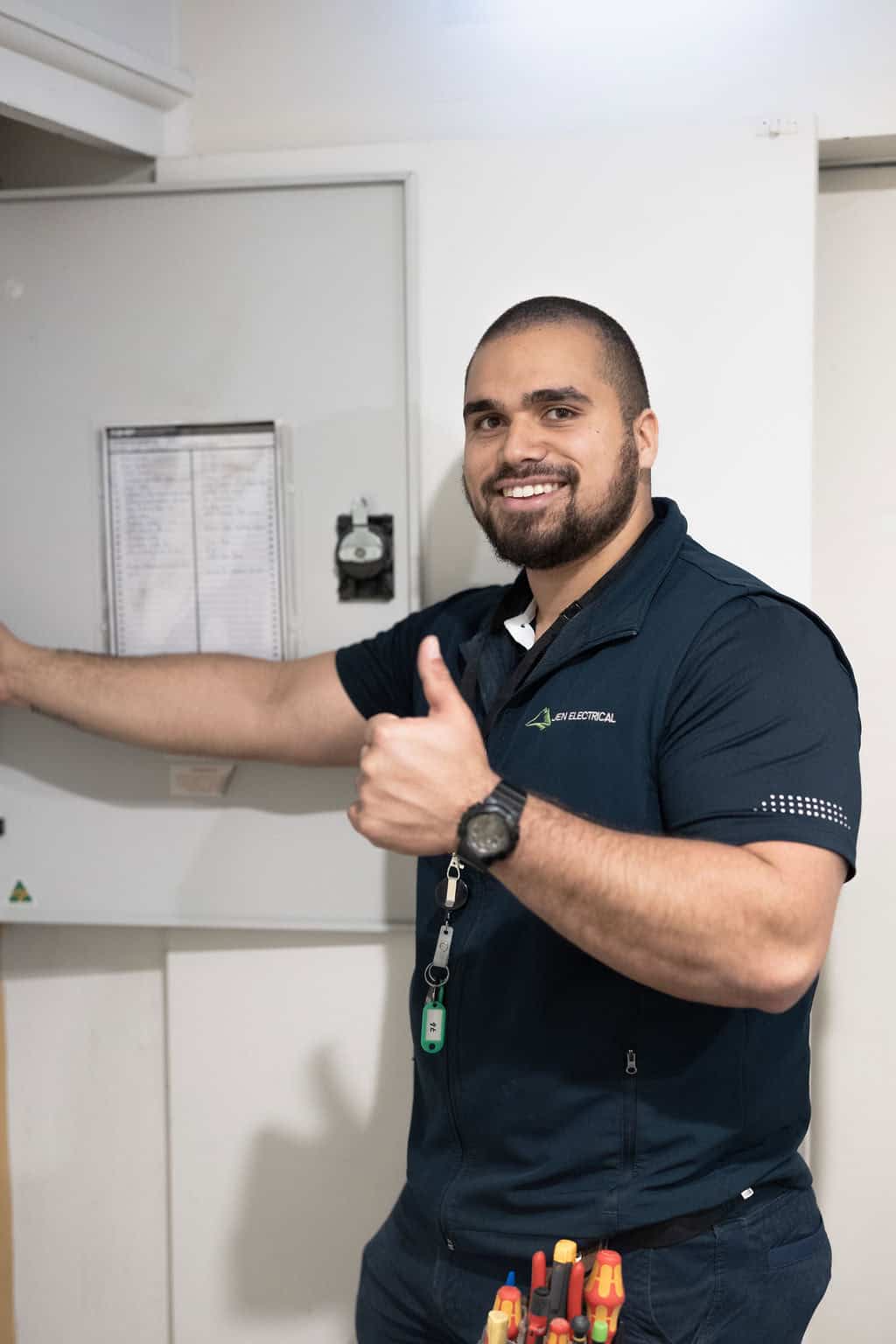 JEN Electrical licensed technician giving thumbs up after completing ceiling fan installation in Melbourne with professional electrical tools and mounting expertise