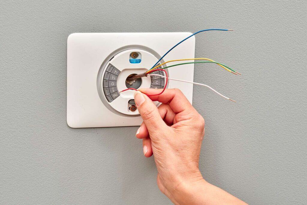 Licensed electrician installing smart thermostat system in Australian home